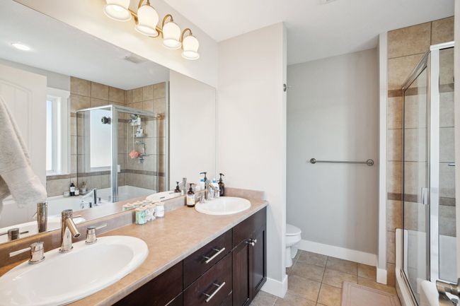 Bathroom with a shower stall, tile patterned floors, and a sink | Image 20