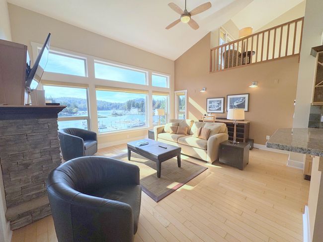 Living area featuring high vaulted ceiling, ceiling fan, and light wood-style flooring | Image 8