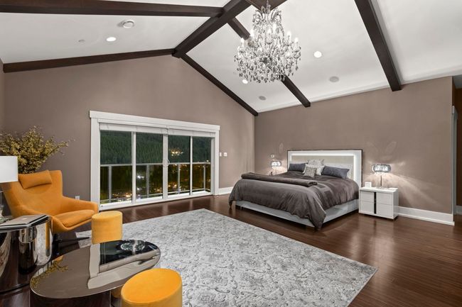 Bedroom with baseboards, wood finished floors, beam ceiling, and an inviting chandelier | Image 21
