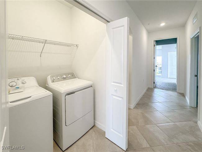 Laundry area with separate washer and dryer, baseboards, and light tile patterned floors | Image 30