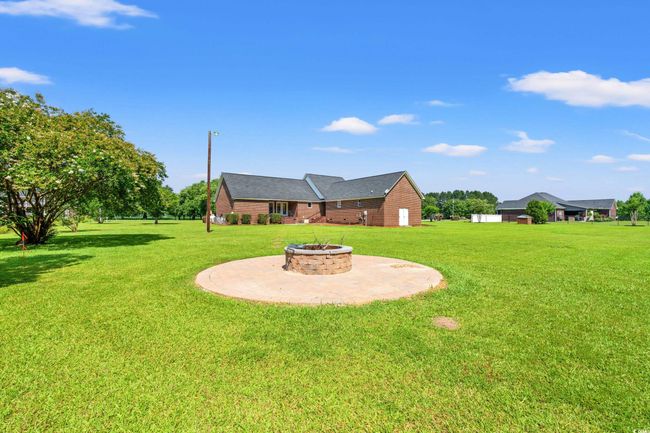 View of grassy yard featuring an outdoor fire pit | Image 27
