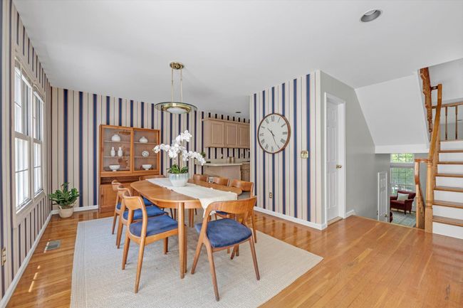 Dining room with light wood-style floors, stairway, and wallpapered walls | Image 6