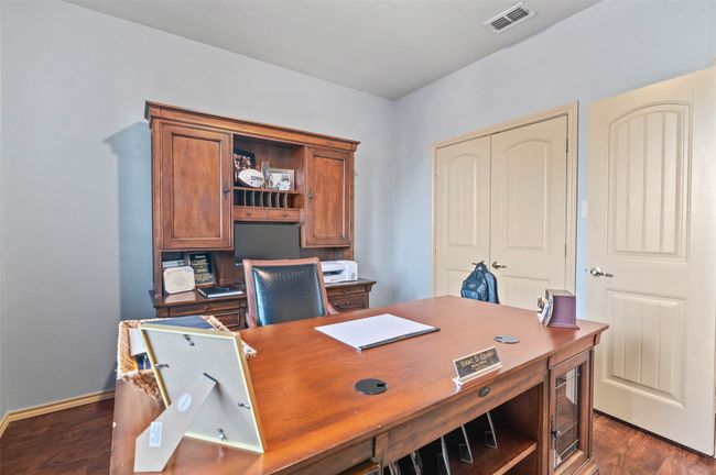 Home office with dark wood finished floors, visible vents, and baseboards | Image 4