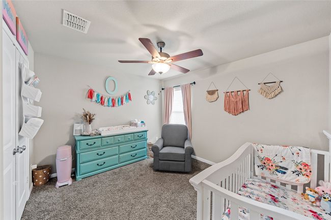 Bedroom featuring a nursery area, carpet, and ceiling fan | Image 9