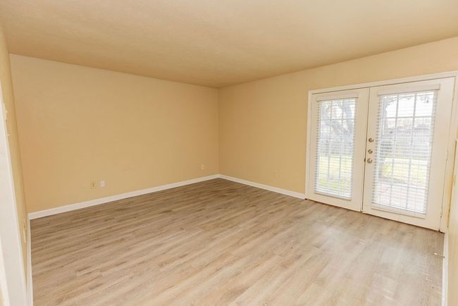 Spare room featuring french doors and light wood-type flooring | Image 6