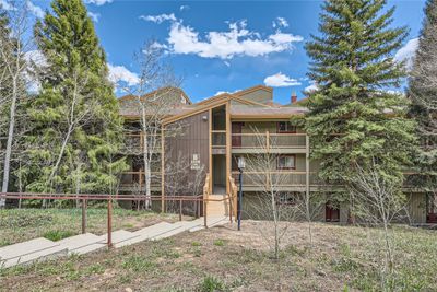 View of building exterior. Front entrance and mature trees surrounding the property | Image 1