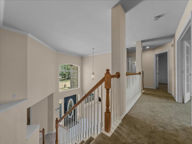 Corridor with carpet flooring, crown molding, and an upstairs landing | Image 16