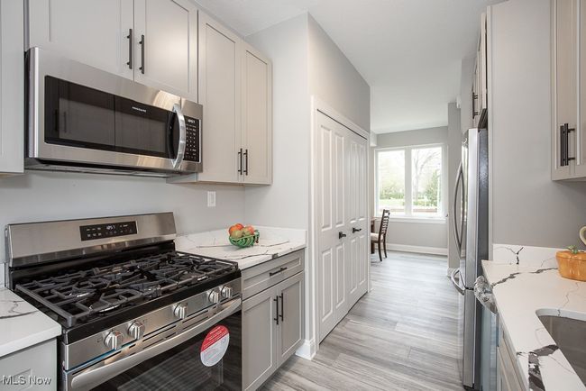 Kitchen featuring light hardwood / wood-style flooring, stainless steel appliances, and light stone countertops | Image 17
