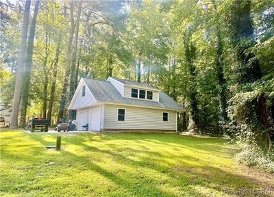 Rear view of house with a garage and a lawn | Image 3