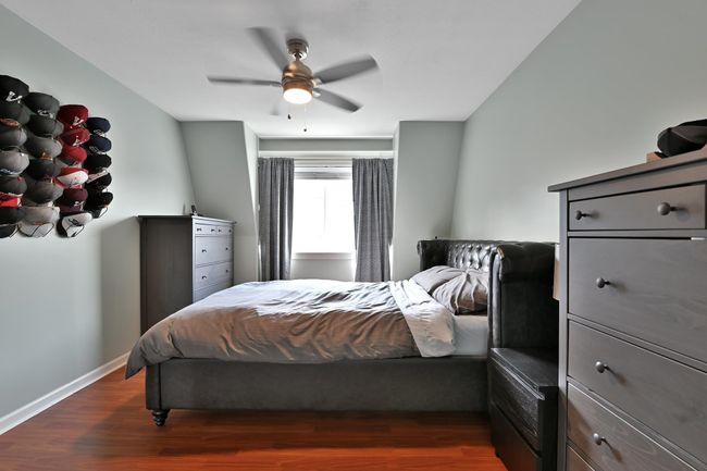 Bedroom with wood finished floors, ceiling fan, and baseboards | Image 25