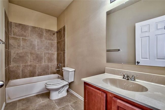 Full bath featuring vanity, bathing tub / shower combination, and tile patterned floors | Image 16