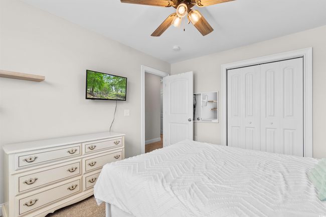 Bedroom with a closet, light colored carpet, and ceiling fan | Image 24