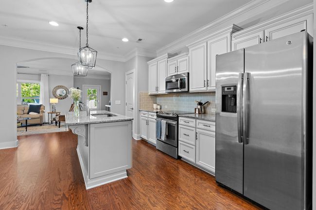 A chic tile backsplash frames the stainless steel appliances. The dishwasher and garbage disposal are brand new! | Image 9