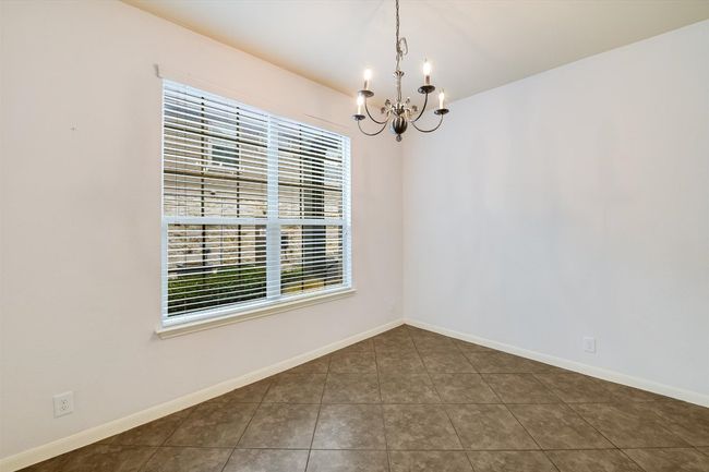 Spare room featuring a chandelier, healthy amount of natural light, and tile patterned flooring | Image 7