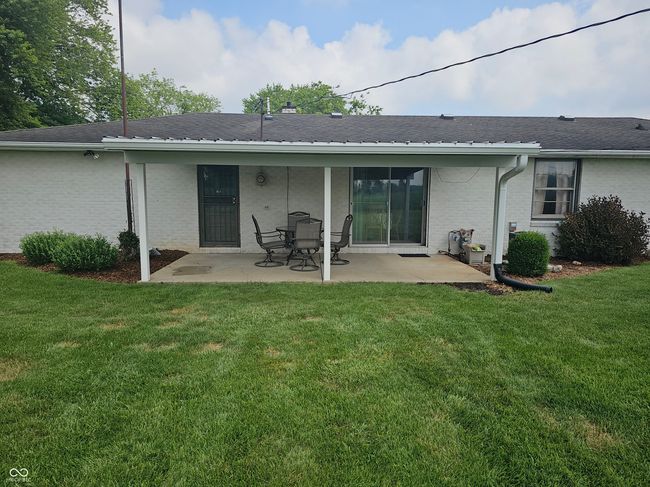 back of property with a patio area, a yard, brick siding, and roof with shingles | Image 6