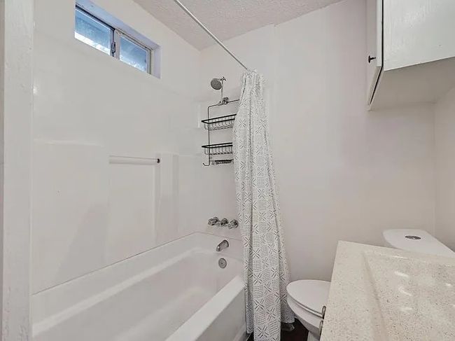Bathroom featuring shower / bathtub combination with curtain and vanity | Image 12