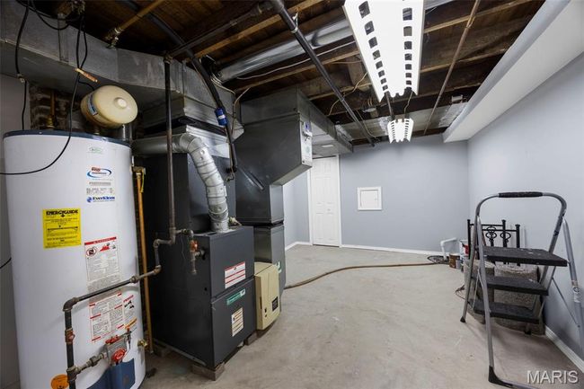 Unfinished below grade area featuring water heater and baseboards | Image 27