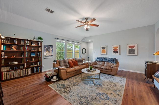 Living area with ceiling fan, baseboards, and wood finished floors | Image 5