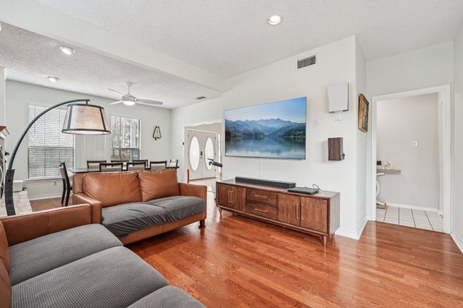 Living area featuring light wood finished floors, a textured ceiling, a ceiling fan, and recessed lighting | Image 6