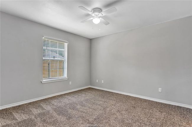 Carpeted empty room with a ceiling fan and baseboards | Image 12