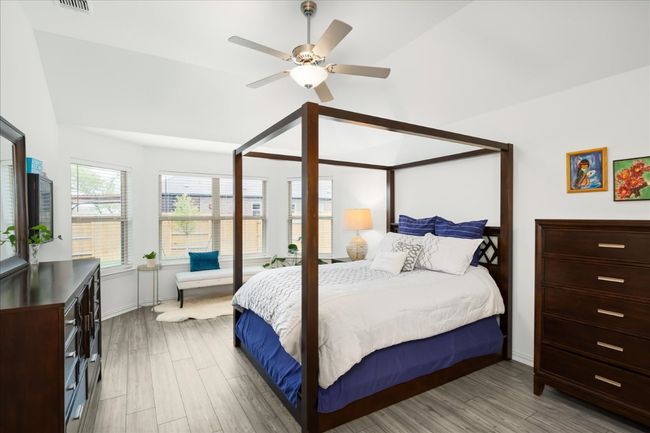 Bedroom with light wood-type flooring, ceiling fan, and vaulted ceiling | Image 9