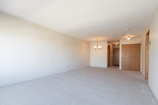 Spare room with light colored carpet and a notable chandelier | Image 7