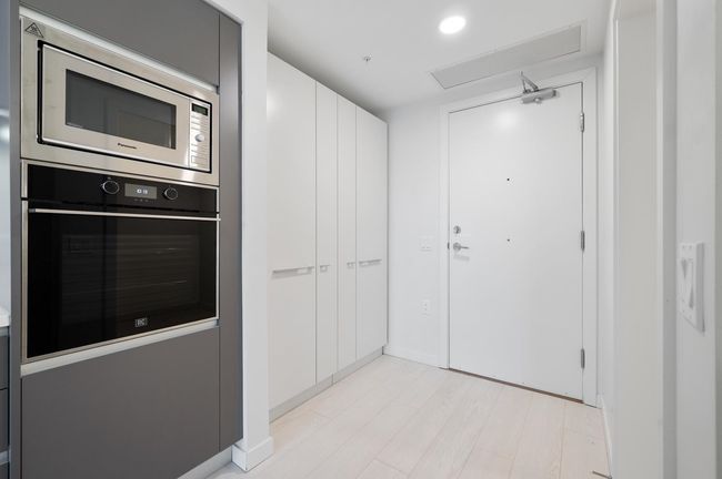 Kitchen featuring light wood-style floors, visible vents, recessed lighting, stainless steel microwave, and oven | Image 13