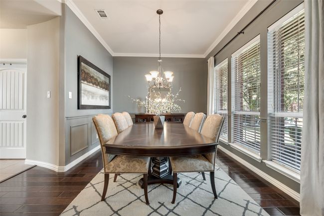 Dining room featuring dark wood-style floors, a chandelier, and ornamental molding | Image 10