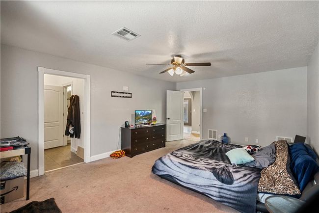 Carpeted bedroom with ceiling fan and a textured ceiling | Image 26