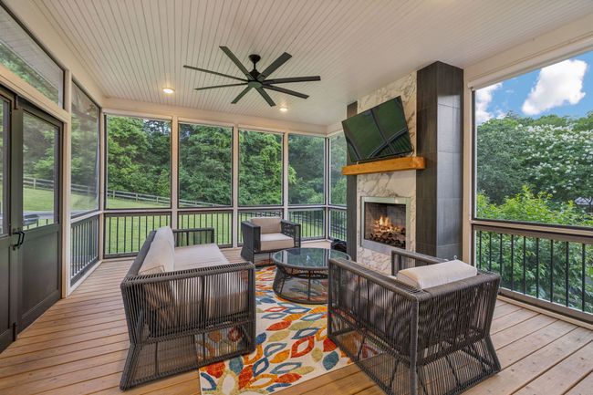 Screened in porch with gas fireplace and peaceful views of the private backyard. | Image 21