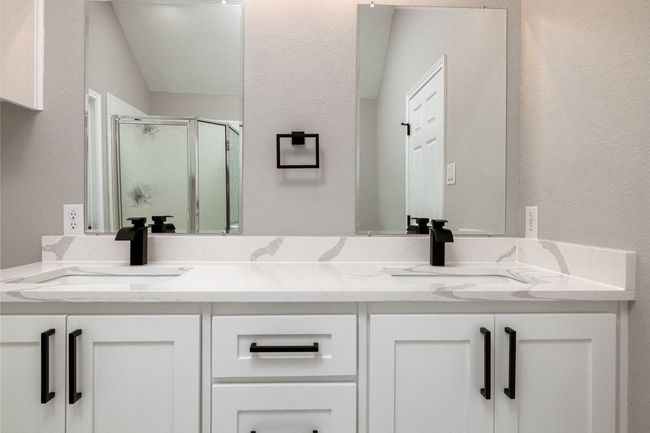 Full bath featuring double vanity, a stall shower, and a textured wall | Image 32