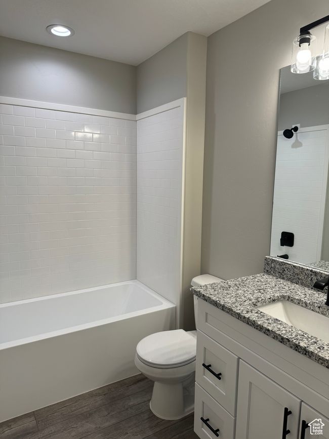 Full bathroom featuring vanity, toilet, tiled shower / bath combo, and wood-type flooring | Image 9
