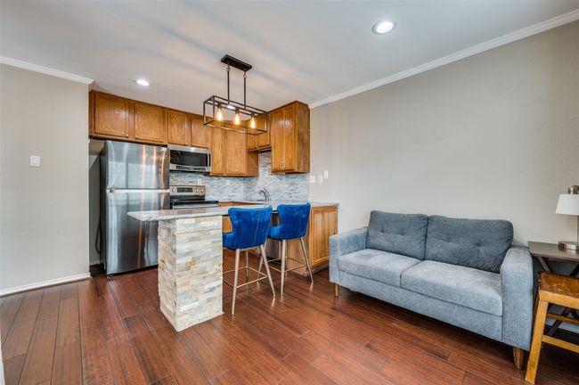 Kitchen with stainless steel appliances, open floor plan, ornamental molding, tasteful backsplash, and a peninsula | Image 4