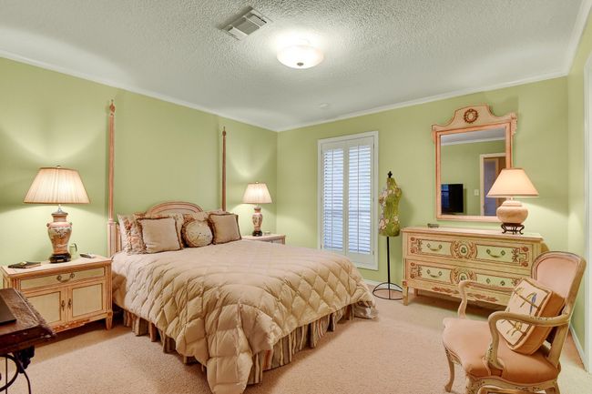 Bedroom featuring light colored carpet, crown molding, and a textured ceiling | Image 26