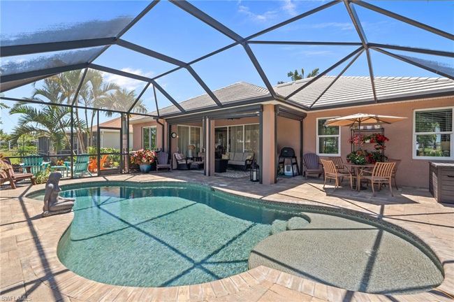 Outdoor pool featuring a patio area, ceiling fan, an outdoor living space, and a lanai | Image 40