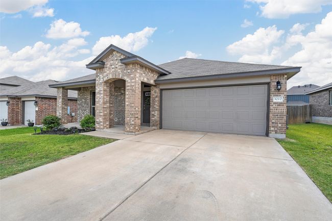 View of front of property with brick siding, driveway, an attached garage, and roof with shingles | Image 4