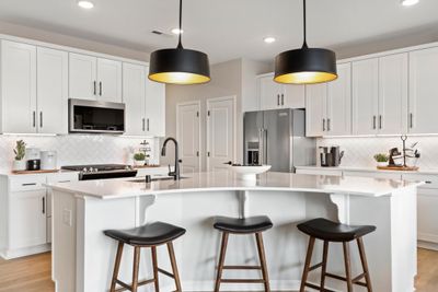 A truly one-of-a-kind kitchen island is the center piece of this kitchen. Equally beautiful and functional. This island is sure to impress while allowing for any undertaking in the kitchen! Photo of model home. | Image 2