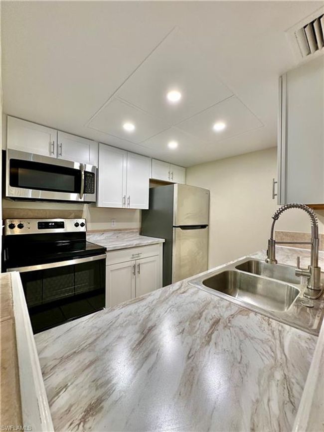 Kitchen featuring appliances with stainless steel finishes, white cabinetry, and recessed lighting | Image 4