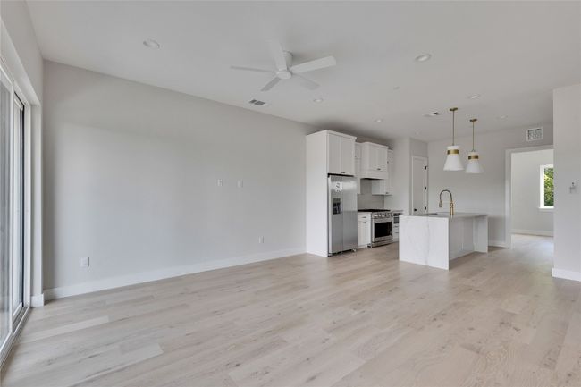 Unfurnished living room with ceiling fan, light wood-type flooring, baseboards, and recessed lighting | Image 22