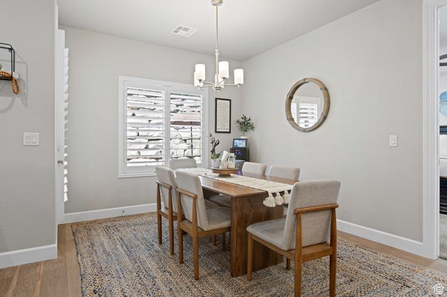 Dining space with light wood-style floors and a chandelier | Image 38