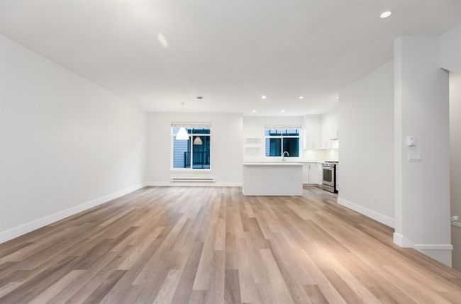 Unfurnished living room featuring recessed lighting, light wood-style floors, baseboards, and a sink | Image 5