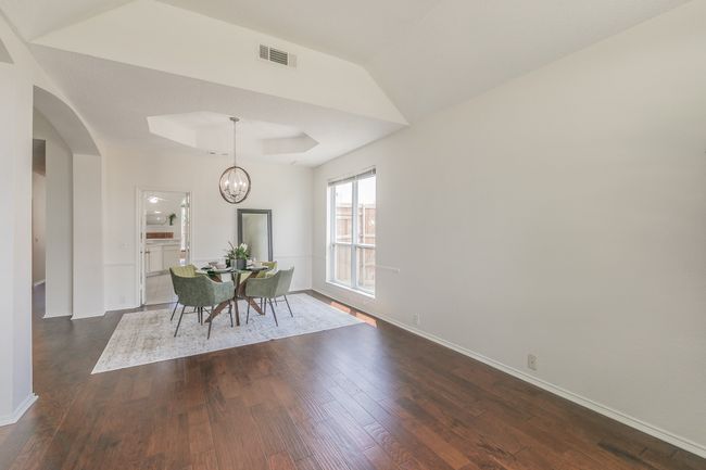 Dining space featuring dark wood-type flooring, arched walkways, and visible vents | Image 7