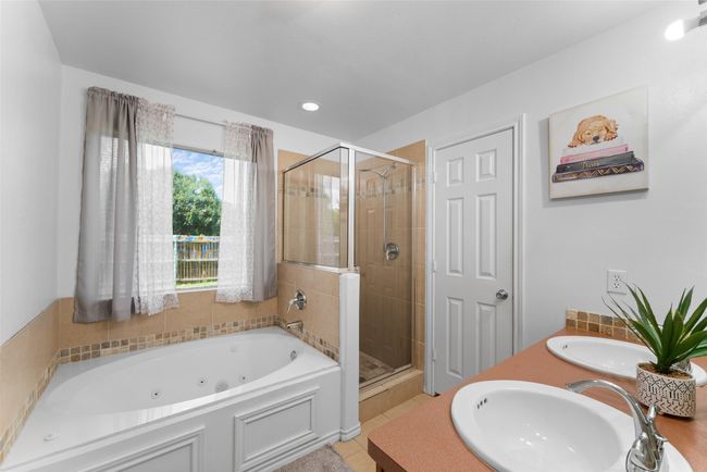 Full bathroom featuring a shower stall, a tub with jets, double vanity, tile patterned floors, and recessed lighting | Image 19