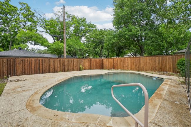 View of swimming pool with a fenced backyard and a patio | Image 38
