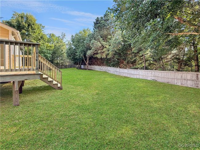 Fenced backyard with a deck and view of wooded area | Image 24