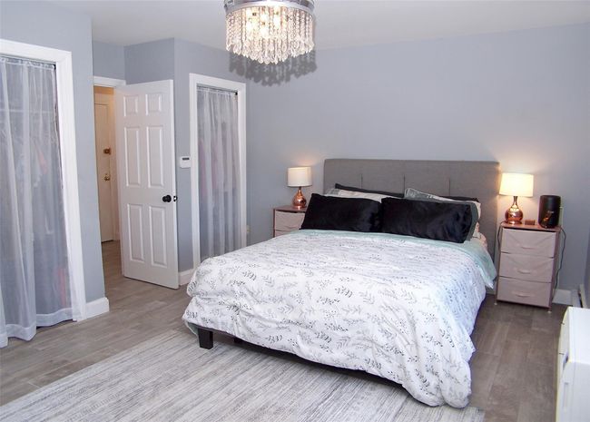 Bedroom featuring hardwood / wood-style flooring and a chandelier | Image 7