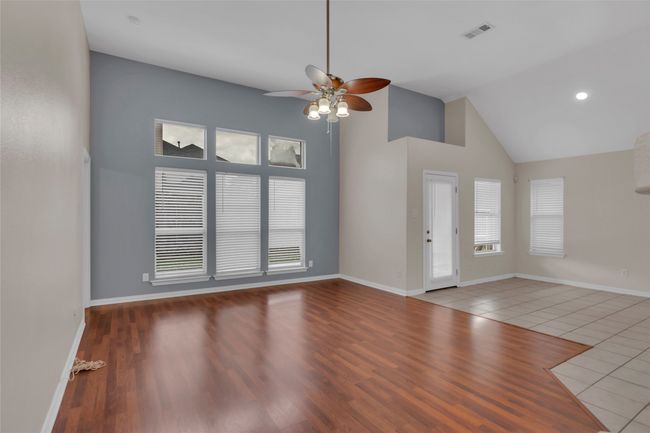 Unfurnished living room with ceiling fan, high vaulted ceiling, and tile patterned flooring | Image 13