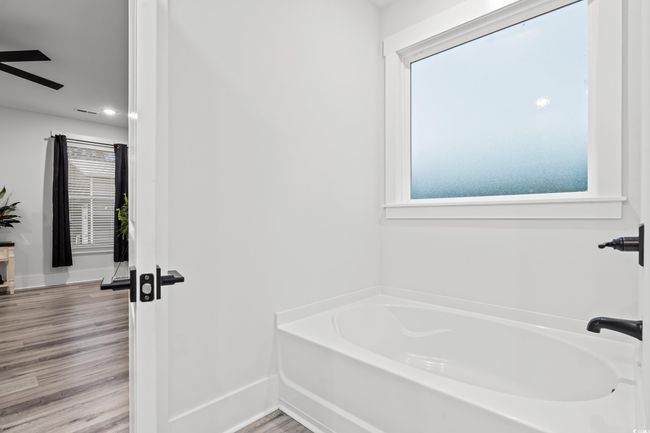 Bathroom featuring a bath, healthy amount of natural light, a ceiling fan, and recessed lighting | Image 13