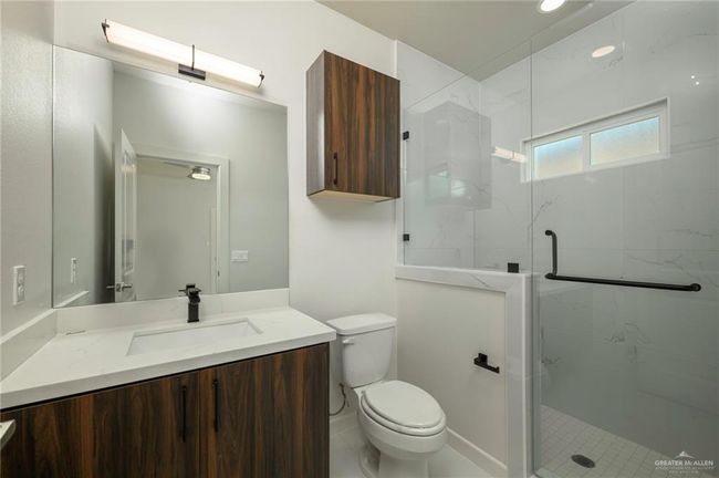 Bathroom featuring a marble finish shower, toilet, and vanity | Image 18