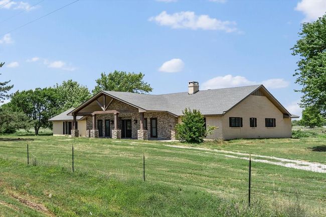 View of front of home with a front yard, a chimney, and brick siding | Image 8